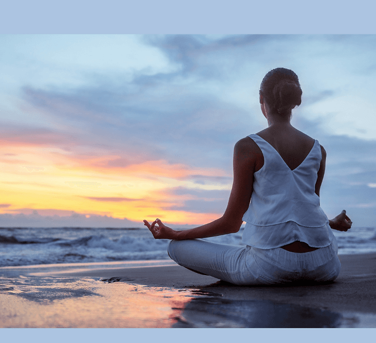 Personne en méditation au coucher de soleil sur la plage
